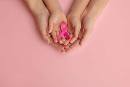 Woman and child holding pink ribbon on color background, top view with space for text. Breast cancer awarenessの写真素材