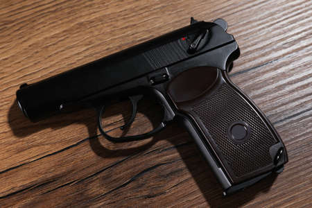 Handgun on wooden table, top view. Semi-automatic pistolの写真素材