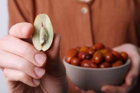Woman holding half of fresh Ziziphus jujuba fruit, closeupの写真素材