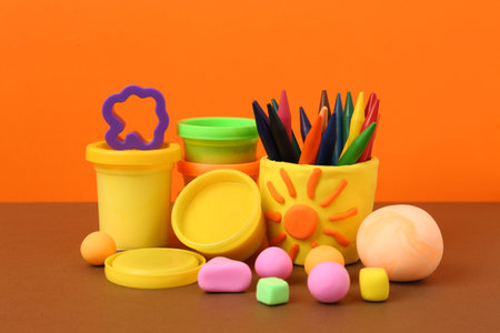 Set of bright play dough with mold and pencils on color backgroundの写真素材