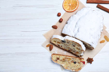 Traditional Christmas Stollen with icing sugar on white wooden table, flat lay. Space for textの写真素材