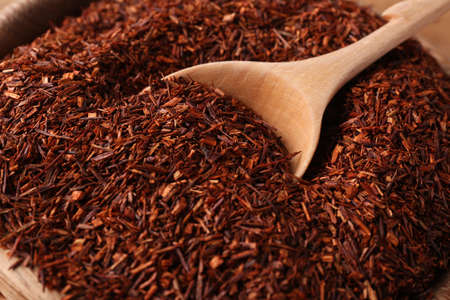 Spoon dry rooibos leaves in wooden bowl, closeupの写真素材