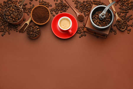 Flat lay composition with coffee grounds and roasted beans on brown background, space for textの写真素材