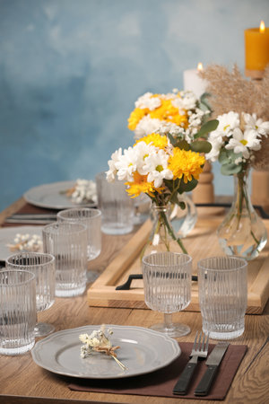 Elegant festive setting with floral decor on wooden tableの写真素材