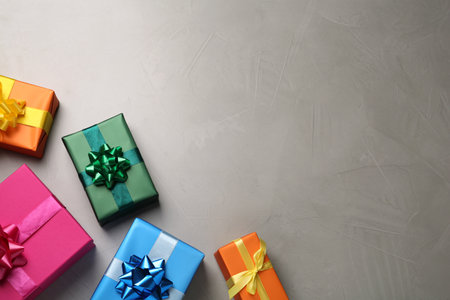Many colorful gift boxes on light gray table, flat lay. Space for text