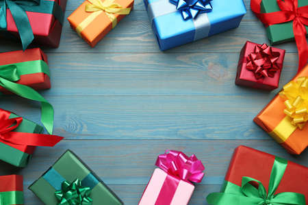 Frame of gift boxes on light blue wooden table, flat lay. Space for textの写真素材