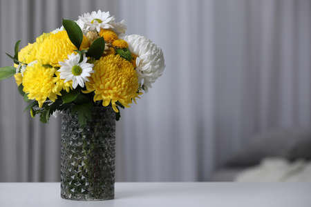 Bouquet of beautiful chrysanthemum flowers on table in room, space for textの写真素材