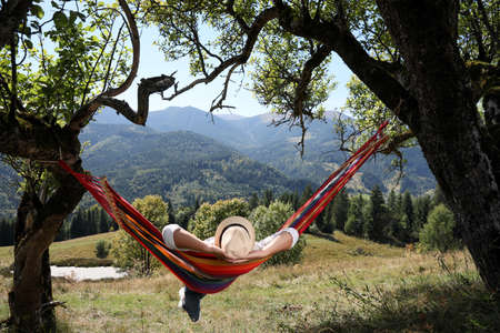 Man resting in hammock outdoors on sunny dayの写真素材