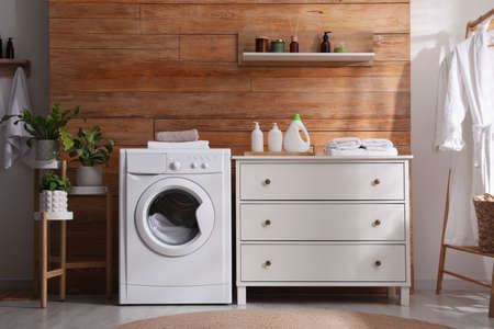 Laundry room interior with washing machine and stylish furnitureの写真素材