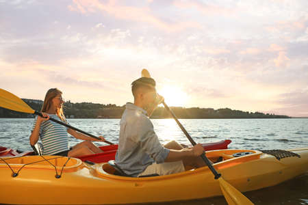 Couple kayaking on river at sunset. Summer activityの写真素材