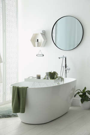 Stylish bathroom interior with modern tub, houseplants and beautiful decor. Home designの写真素材