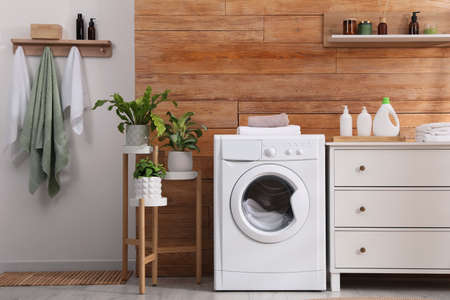 Laundry room interior with washing machine and stylish furnitureの写真素材