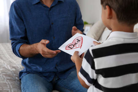 Little boy greeting his dad with Father's Day at home, closeupの写真素材