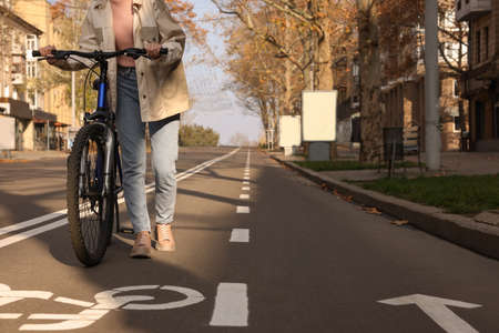 Woman with bicycle on lane in city, closeupの写真素材
