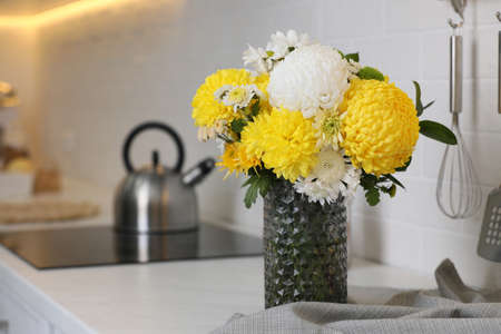 Bouquet of beautiful chrysanthemum flowers on countertop in kitchen, space for textの写真素材