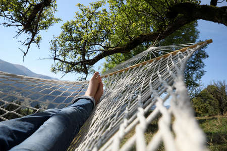 Man resting in hammock outdoors on sunny day, closeupの写真素材