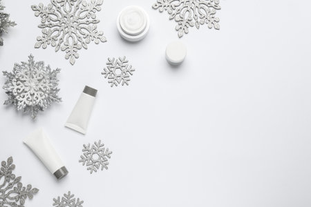 Composition with cosmetic products and snowflakes on white background, top view. Winter skin careの写真素材