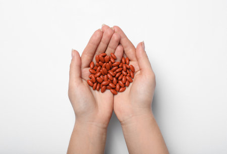 Woman holding pills on white background, top view. Anemia treatmentの写真素材