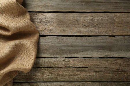 Natural burlap fabric on wooden table, top view. Space for textの写真素材