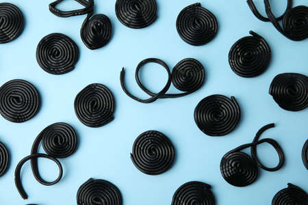 Tasty black liquorice candies on light blue background, flat layの写真素材