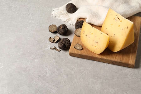 Delicious cheese and fresh black truffles on gray table. Space for textの写真素材
