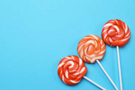 Sweet lollipops on light blue background, flat lay. Space for textの写真素材