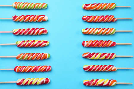 Sweet lollipops on light blue background, flat lay