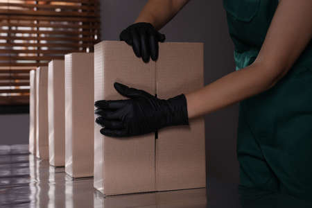 Woman packing cardboard boxes at production line indoors, closeupの写真素材