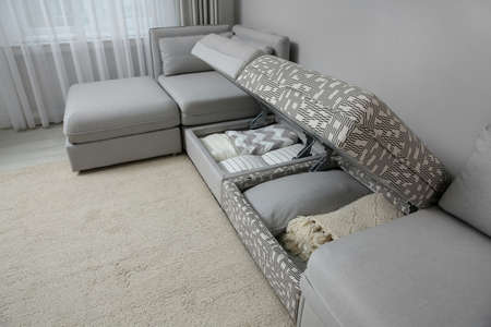 Modular sofa with storage near wall in living room. Interior design