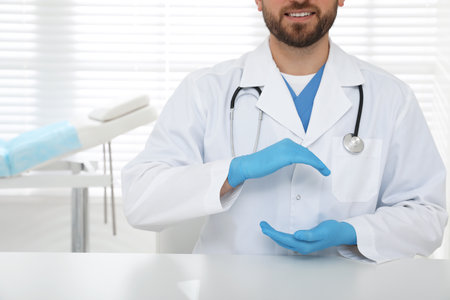 Young doctor holding something at table in clinic, closeupの写真素材