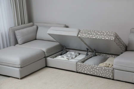 Modular sofa with storage near wall in living room. Interior design