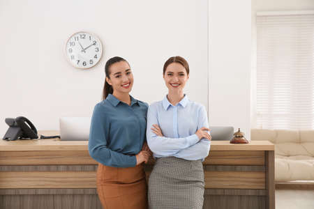 Portrait of beautiful receptionists near counter in hotelの写真素材