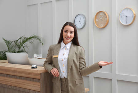 Portrait of beautiful receptionist near counter in hotelの写真素材