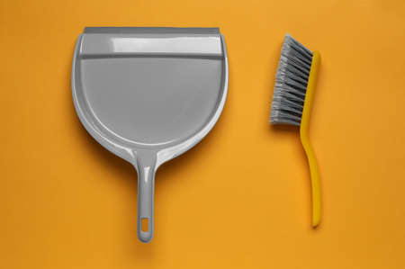 Plastic hand broom and scoop on yellow background, flat layの写真素材