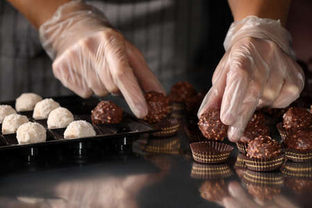 Woman packing delicious candies at production line, closeupの写真素材