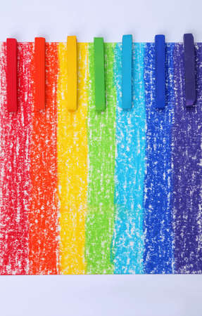 Colorful pastel chalks on rainbow painting, flat lay. Drawing materialsの写真素材