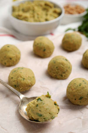 Raw falafel balls and spoon on parchment, closeupの写真素材