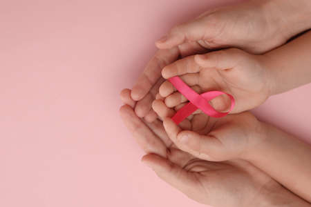 Woman and child holding pink ribbon on color background, top view with space for text. Breast cancer awarenessの写真素材