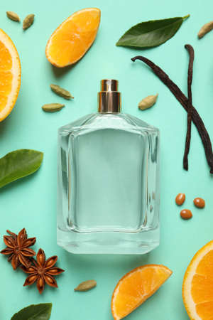 Flat lay composition with bottle of perfume and fresh citrus fruits on turquoise backgroundの写真素材