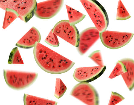 Slices of delicious ripe watermelon falling on white backgroundの写真素材