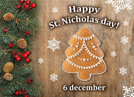 Happy St. Nicholas day, greeting card design. Fir branches and tasty cookie in shape of Christmas tree on wooden background, flat layの写真素材