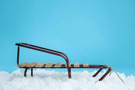 Sleigh and artificial snow on light blue background. Winter outdoor activityの写真素材