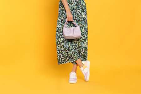 Woman with stylish bag on yellow background, closeupの写真素材