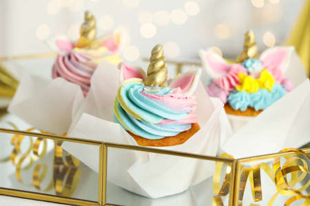 Closeup view of cute sweet unicorn cupcakes on tray, bokeh effect. Festive treatの写真素材