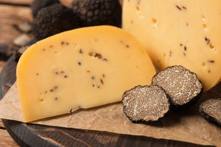 Delicious cheese with fresh truffles on wooden board, closeupの写真素材