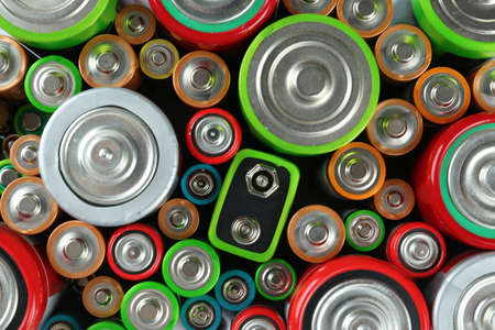 Many batteries of different types as background, top viewの写真素材