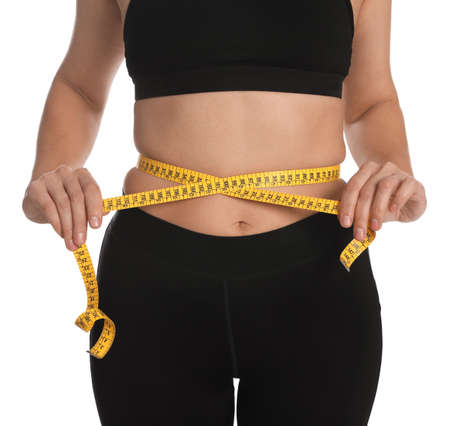 Woman measuring waist with tape on white background, closeupの写真素材