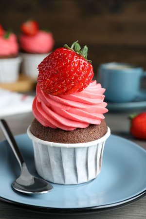 Sweet cupcake with fresh strawberry on plate, closeupの写真素材
