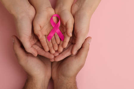 Family holding pink ribbon on color background, top view. Breast cancer awarenessの写真素材