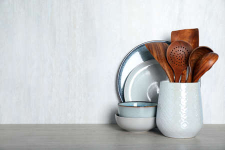 Set of kitchen utensils on light table, space for text